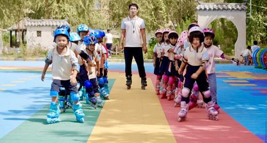 孩子们全副武装在老师指导下练习轮滑。阿卜力克木·依卜拉依木 摄