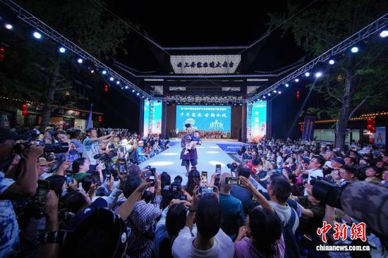 图为当地苗族村民身着传统盛装服饰带着她的孙子在T台走秀。杨武魁 摄
