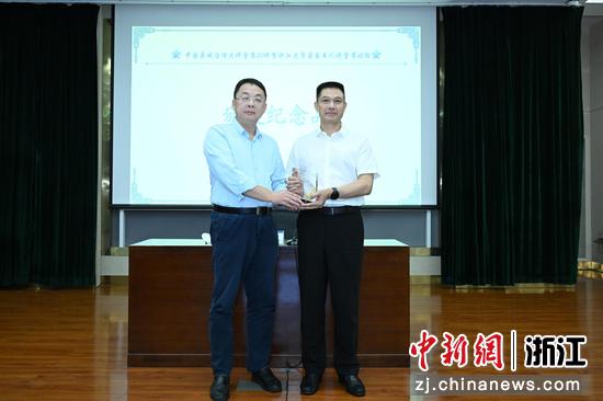 图为:浙江大学公共管理学院求是特聘教授、风险管理与劳动保障研究所所长刘涛为金华市委常委、义乌市委书记叶帮锐颁发纪念品。中新社发 王怿杰 摄