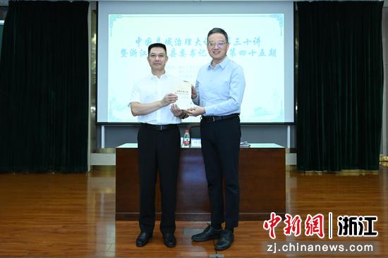 图为:中国新闻社浙江分社副社长严格为金华市委常委、义乌市委书记叶帮锐颁发纪念品。中新社发 王怿杰 摄