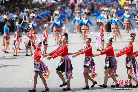 9月20日，身着传统服饰的小朋友在巡游展演中跳苗族锦鸡舞。 杨武魁 摄