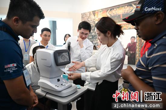 图为:学员们在中国眼谷参观体验全自动视力检测设备。中新社记者 王刚 摄