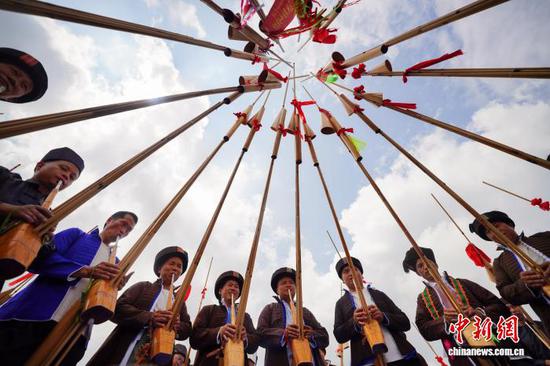 9月20日，身着传统服饰的民众在巡游展演中吹奏芦笙。 杨武魁 摄