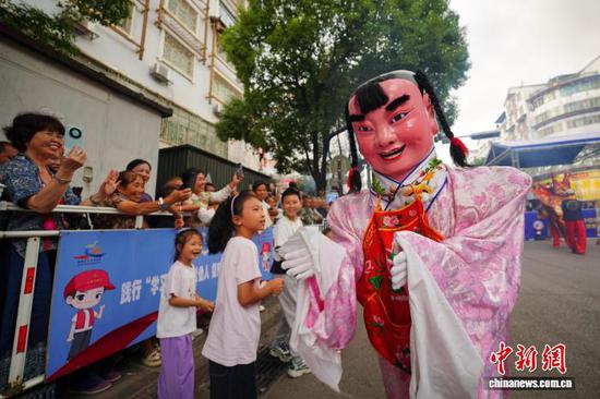 9月20日，福建福州游神表演者在巡游展演中与观众互动。 杨武魁 摄
