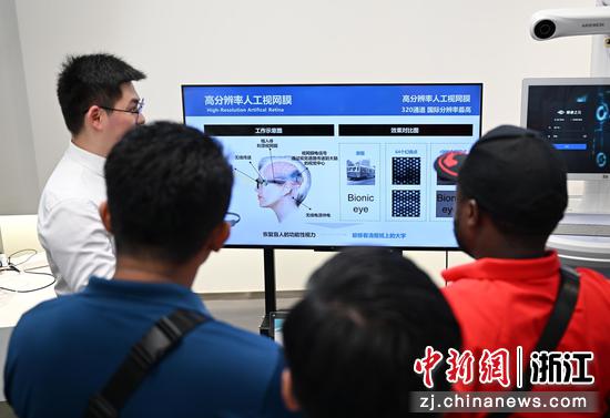 图为:学员们在中国眼谷参观了解高分辨率人工视网膜。中新社记者 王刚 摄