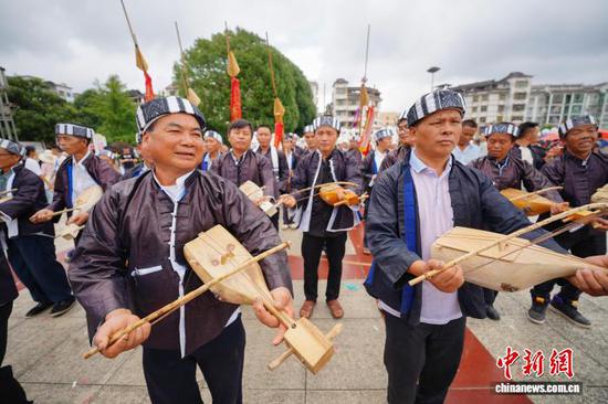9月20日，身着传统服饰的民众在巡游展演中跳古瓢琴舞。 杨武魁 摄