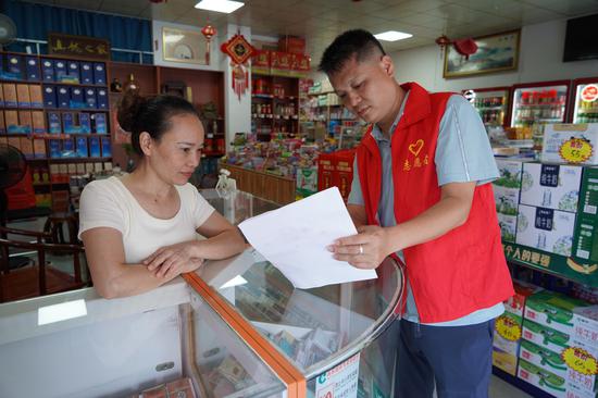 图为烟草志愿者(右)向零售户宣传相关知识。张芳 摄 图为烟草志愿者(右)向零售户宣传相关知识。张芳 摄