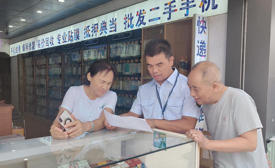 图为向零售户宣传烟草证办理、延续要求。张芳 摄 图为向零售户宣传烟草证办理、延续要求。张芳 摄