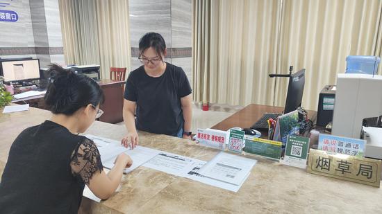 图为烟草窗口人员向咨询群众讲解证件办理相关政策。张芳 摄 图为烟草窗口人员向咨询群众讲解证件办理相关政策。张芳 摄