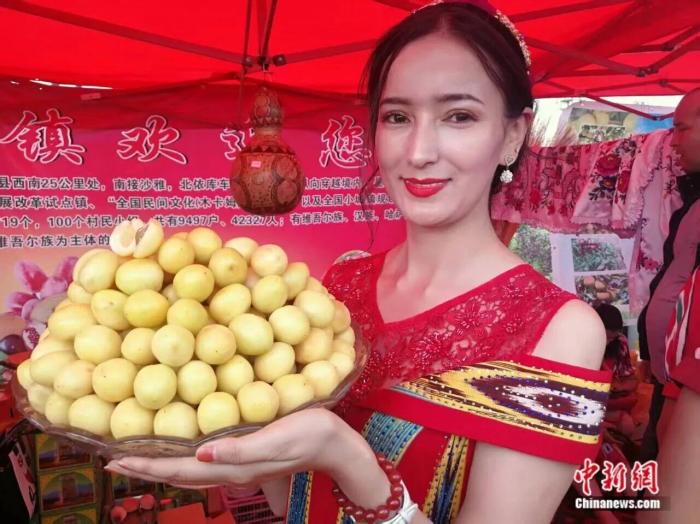 库车市每年举行小白杏采摘节庆活动,当地民众展示小白杏。王小军 摄 库车市每年举行小白杏采摘节庆活动,当地民众展示小白杏。王小军 摄