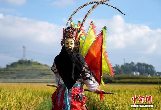 图为9月24日，叶守兴在西秀区旧州镇的稻田间表演地戏。石小杰 摄