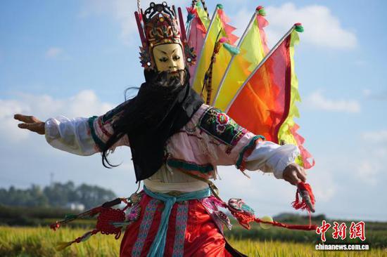图为9月24日，叶守兴在西秀区旧州镇的稻田间表演地戏。石小杰 摄