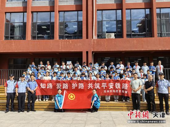 图为北京铁路公安局天津公安处沧州西站派出所民警在学习开展法治宣传，与学校领导、老师和学生合影。（北京铁路公安局天津公安处供图）