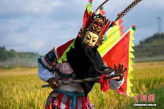 图为9月24日，叶守兴在西秀区旧州镇的稻田间表演地戏。石小杰 摄