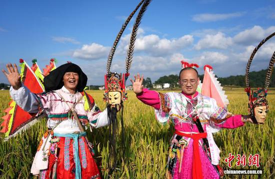 图为9月24日，叶守兴(图左)与叶帅虎(图右)在西秀区旧州镇的稻田间交流地戏表演。石小杰 摄