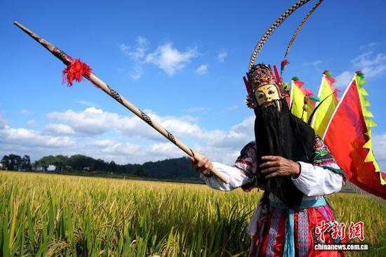 图为9月24日，叶守兴在西秀区旧州镇的稻田间表演地戏。石小杰 摄