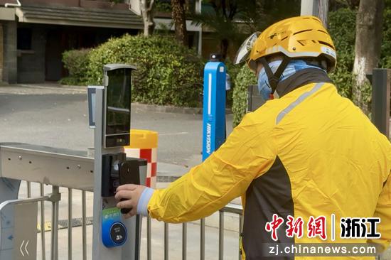9月29日,在浙江金华婺城区,一位外卖员在小区门口“亮码”通行。董易鑫 摄 9月29日,在浙江金华婺城区,一位外卖员在小区门口“亮码”通行。董易鑫 摄