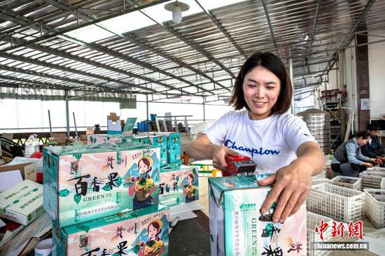 图为村民包装百香果。史开心 摄