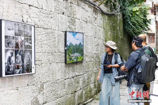 图为摄影师在贵州省安顺市旧州古镇看展。中新网记者瞿宏伦 摄 图为摄影师在贵州省安顺市旧州古镇看展。中新网记者瞿宏伦 摄