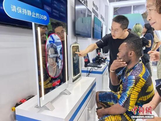 图为外籍人士体验智慧面诊仪。张煜欢 摄 图为外籍人士体验智慧面诊仪。张煜欢 摄