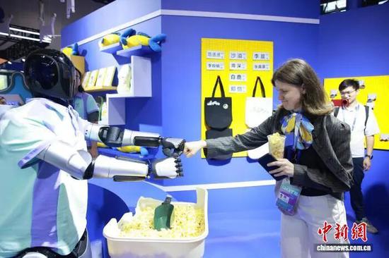 第四届全球数贸会主题展区,国际客商与现场展出的人形机器人互动。孙杨洋 摄 第四届全球数贸会主题展区,国际客商与现场展出的人形机器人互动。孙杨洋 摄