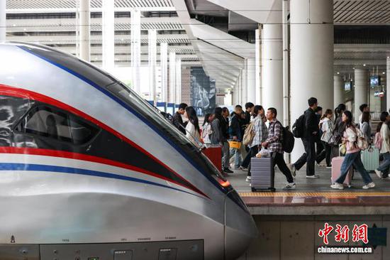 10月1日，旅客在贵阳北站月台上、下车。当日是2025年国庆中秋假期第一天，贵阳北站开行列车506趟，刷新开站以来单日开行列车趟数纪录，迎来客流高峰。中新社记者 瞿宏伦 摄