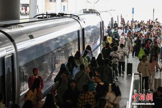 10月1日，旅客在贵阳北站月台上、下车。当日是2025年国庆中秋假期第一天，贵阳北站开行列车506趟，刷新开站以来单日开行列车趟数纪录，迎来客流高峰。中新社记者 瞿宏伦 摄
