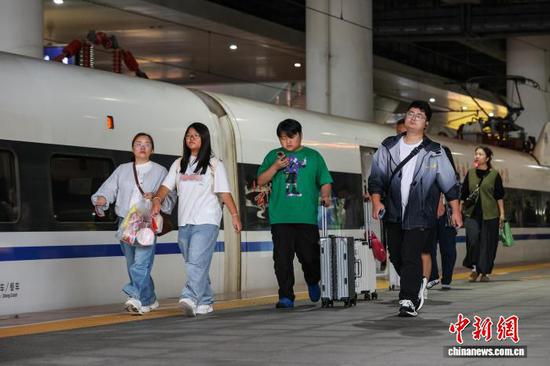 10月1日，旅客步入贵阳北站月台。当日是2025年国庆中秋假期第一天，贵阳北站开行列车506趟，刷新开站以来单日开行列车趟数纪录，迎来客流高峰。中新社记者 瞿宏伦 摄