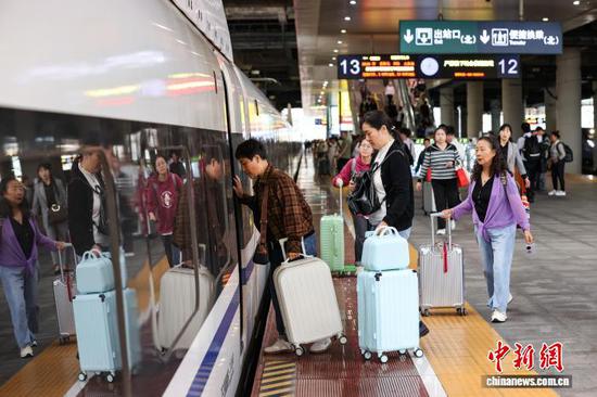 10月1日，旅客在贵阳北站月台登车。当日是2025年国庆中秋假期第一天，贵阳北站开行列车506趟，刷新开站以来单日开行列车趟数纪录，迎来客流高峰。中新社记者 瞿宏伦 摄