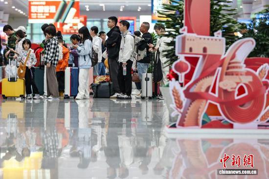 10月1日，旅客在贵阳北站候车大厅排队等待检票。当日是2025年国庆中秋假期第一天，贵阳北站开行列车506趟，刷新开站以来单日开行列车趟数纪录，迎来客流高峰。中新社记者 瞿宏伦 摄