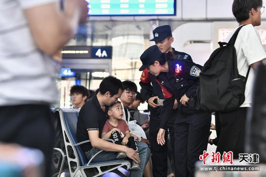图为北京铁路公安局天津公安处天津站派出所执勤民警在候车室巡逻巡视，热心解答旅客询问。（北京铁路公安局天津公安处供图）