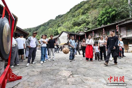 10月2日，游客在云山屯体验蹴鞠敲锣游戏。中新社记者 瞿宏伦 摄