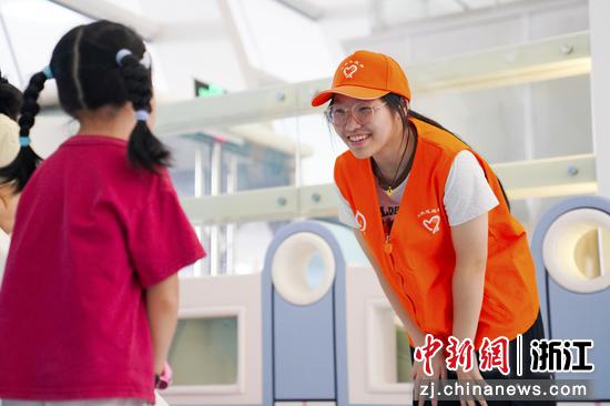 铁路志愿者与儿童旅客沟通互动。汤鑫严 摄