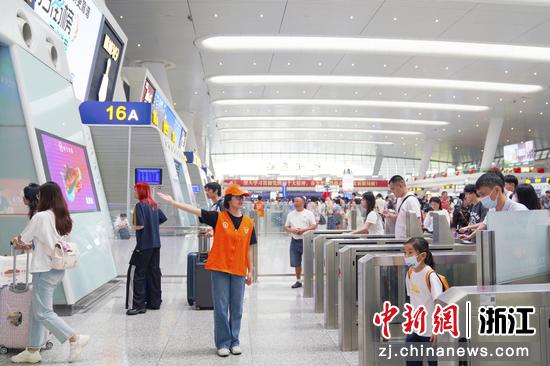 10月1日,杭州东站候车大厅内,志愿者引导旅客通行。汤鑫严 摄