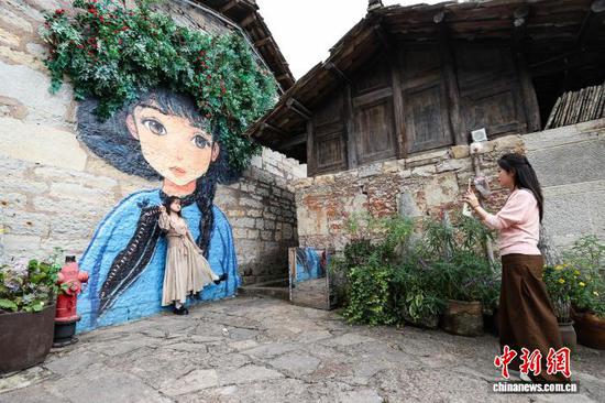 10月2日，游客在云山屯打卡拍照。中新社记者 瞿宏伦 摄