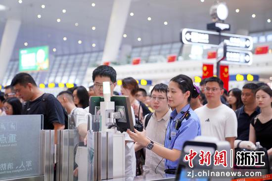 杭州东站内,旅客排队经过验票通道。汤鑫严 摄