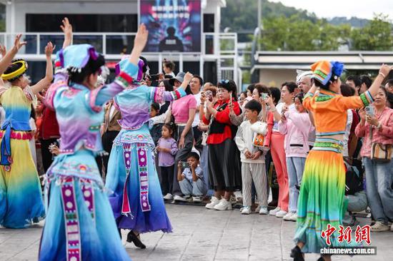 图为巡游节目表演吸引民众观看。中新社记者 瞿宏伦 摄