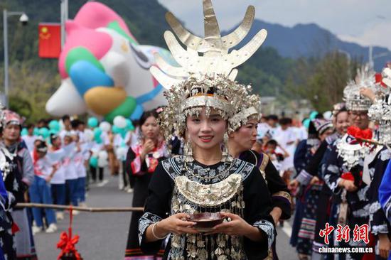 图为10月1日，水族民众组成方队进行巡游。端节在水语中称为借端或过端，被誉为“世界最长的年节”。2006年，水族端节被列入中国国家级非物质文化遗产名录。记者 刘美伶 摄