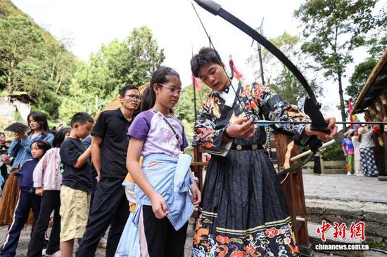 10月2日，工作人员在教授游客射箭技巧。中新社记者 瞿宏伦 摄