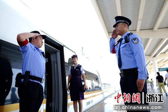 图为:站台上,列车停稳。站台民警与列车乘警目光交汇,相互立正,庄严敬礼。这一瞬的无声交流,是职责的交接,是节日的问候,更是对旅客平安的共同守护。中新社发 贺瑞明 摄