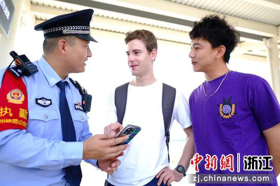 图为:民警在站台,巧用APP翻译软件,为需要帮助的外籍旅客提供咨询引导。中新社发 贺瑞明 摄