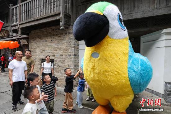 10月4日，乌江寨巨型“鹦鹉”人偶吸引游客。中新社记者 瞿宏伦 摄