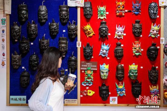 10月4日，乌江寨的傩戏面具吸引游客。中新社记者 瞿宏伦 摄