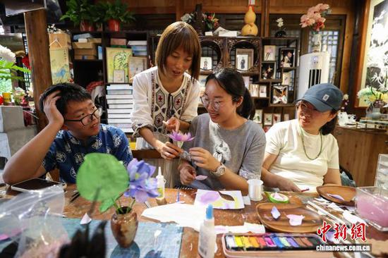 10月4日，游客在乌江寨体验通草堆画制作。中新社记者 瞿宏伦 摄