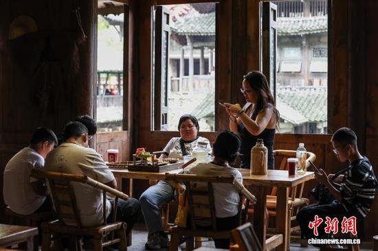 10月4日，游客在乌江寨一家茶馆喝下午茶。中新社记者 瞿宏伦 摄