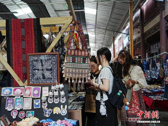 10月5日，游客在贵州省凯里市绣里淘非遗集市挑选心仪的产品。中新社记者 周燕玲 摄