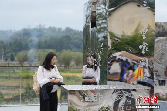 图为游客在安顺市西秀区旧州古镇观赏艺术装置《归乡·屯堡高台》。石小杰 摄