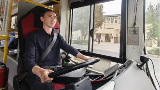 洛浦县3路公交车行驶中，司机专注驾驶，观察前方路况。