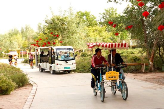 游客在伽师县城中胡杨生态园景区游逛