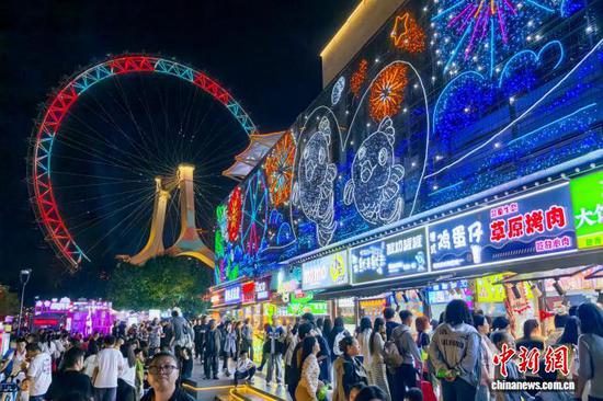图为10月3日晚，市民和游客在天津之眼摩天轮市集打卡游玩。记者 佟郁 摄